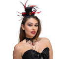 Woman wearing a mini black top hat with red and black feathers, and a black lace necklace with red jewel