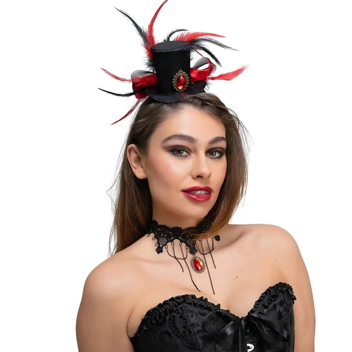 Woman wearing a mini black top hat with red and black feathers, and a black lace necklace with red jewel