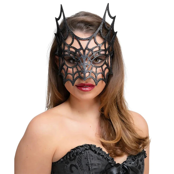 Woman wearing a spiders web mask in black glitter for a masquerade ball or fancy dress party
