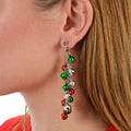 Model wearing jingle bell drop earrings with red, green and silver baubles