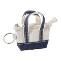 Small tote bag keychain with navy accents on a white background