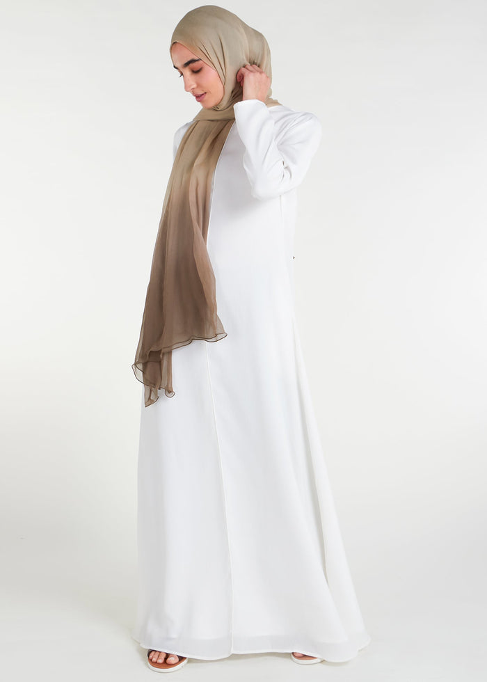 Long Line Abaya in Classic White, featuring a flattering silhouette that effortlessly complements your style. Experience comfort and sophistication in every step with this must-have addition to your modest collection.